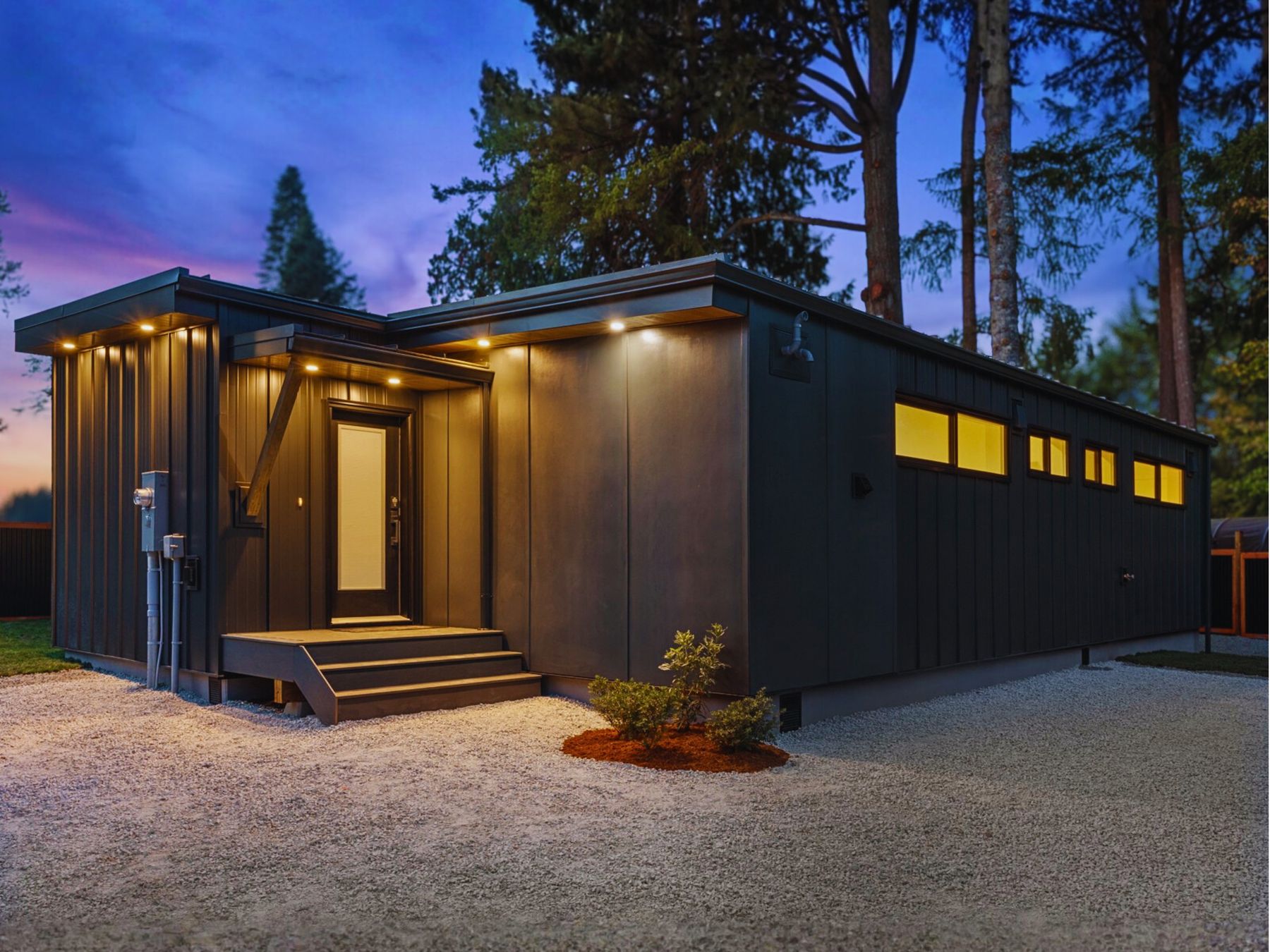 A completed modular residence with an outdoor deck, twilight exterior
